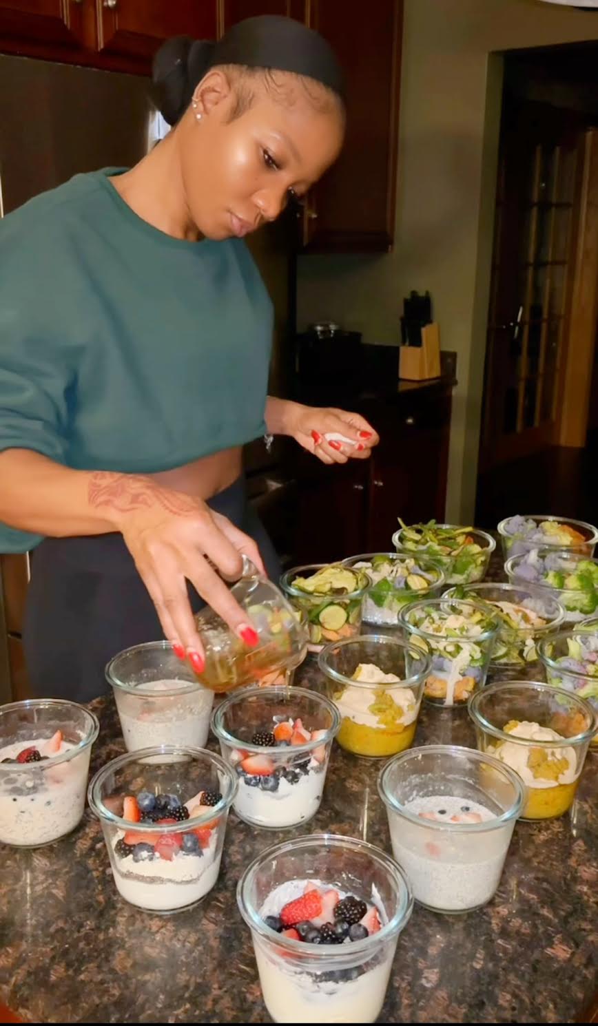 Woman preparing meal prep containers in a kitchen.